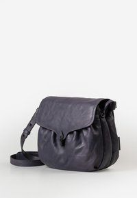 Borsa a tracolla in pelle di un viola scuro con chiusura a patta, tracolla regolabile e texture morbida. Presenta pieghe sottili per definire la forma.