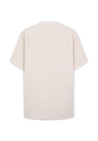 Camicia beige a maniche corte con un sottile motivo testurizzato, vista posteriore piatta, con cucitura a yoke sulle spalle.