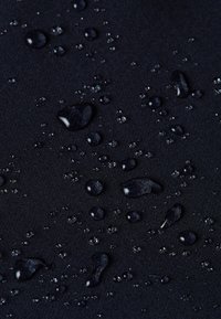 Waterdichte stof in donker marineblauw, met druppels op het oppervlak, die een gladde textuur en een gelijkmatige afwerking tonen.