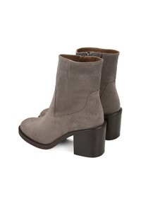 Graue Wildleder-Stiefeletten mit runder Spitze, seitlichen Nahtdetails und Blockabsatz. Das Innere ist mit braunem Futter und einem Reißverschluss ausgestattet.