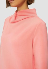 Lichtroze top met colhals, gemaakt van gladde stof, met een relaxte pasvorm en subtiele textuur, met een iets oversized ontwerp bij de hals.
