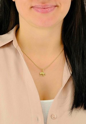 Goldenes Elefantenanhänger-Halskettchen an einer goldenen Kette, getragen über einem hellfarbenen Oberteil, mit einem strukturierten, detaillierten Design.