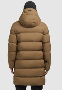 Brun pufferjakke med hætte, der har et quiltet design, elastiske manchetter og tekstureret stof. Synlig logoetikette bagpå.