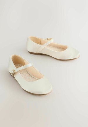 Weiße Ballerinas aus Satin mit abgerundeter Spitze, Knöchelriemen und dekorativer Schnalle. Das Innenfutter weist ein leichtes Blumenmuster auf. Flache Sohle.