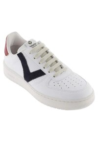 Zapatilla blanca de cuero con logo V en azul marino y talón rojo. Presenta cordones beige y perforaciones para ventilación. Suela de goma.
