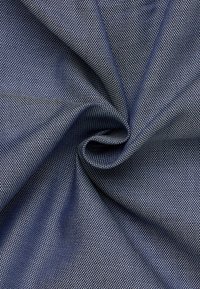 Tessuto blu navy con un pattern tessuto e strutturato. Il materiale è liscio, con una leggerissima lucentezza e un design a griglia uniforme.
