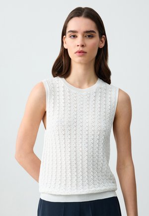 Top bianco senza maniche in maglia con un motivo texturizzato e colletto e cintura a costine. Il tessuto sembra leggero e traspirante.