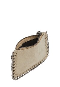 Beżowa zamszowa saszetka z zamkiem błyskawicznym, z ozdobnym łańcuszkiem w kolorze srebrnym wzdłuż krawędzi oraz miękką teksturowaną powierzchnią.