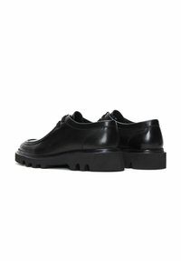 Zwarte leren schoenen met een gladde textuur, afgerond ontwerp en dikke rubberen zool met een gegroefd patroon. Vetersluiting aan de voorkant.