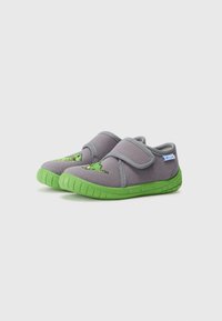 Grå stoffsko med grønne gummisåler, med et dinosaurdesign på siden og en borrelåsrem for enkel påkledning.