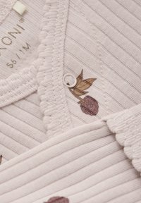 Ljusrosa ribbad tröja med broderade blad och bär, med rund hals och knappstängning. Mjuk textur och delikata detaljer.
