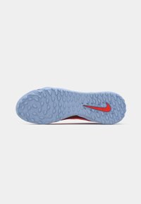 Light blue textured rubber sole of a sports shoe with a red Nike swoosh logo near the heel.