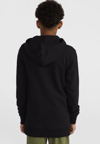 Sweat-shirt noir à capuche avec une coupe décontractée, des manches longues et une poche kangourou. Texture lisse, design épuré et un dos légèrement plus long.