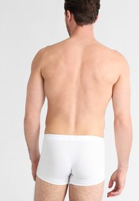 Witte katoenen boxershorts met een gladde textuur en een elastische tailleband, gezien van achteren. Eenvoudig ontwerp zonder patronen of merken.