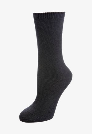Zwarte sokken tot de helft van het been met ribbelboord, gemaakt van gebreide stof, gepresenteerd op een voetvorm tegen een witte achtergrond.