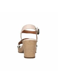 Beige hoge hakken sandalen met een kurkplatform, verstelbare achterband en decoratieve hardware accenten op de hak.