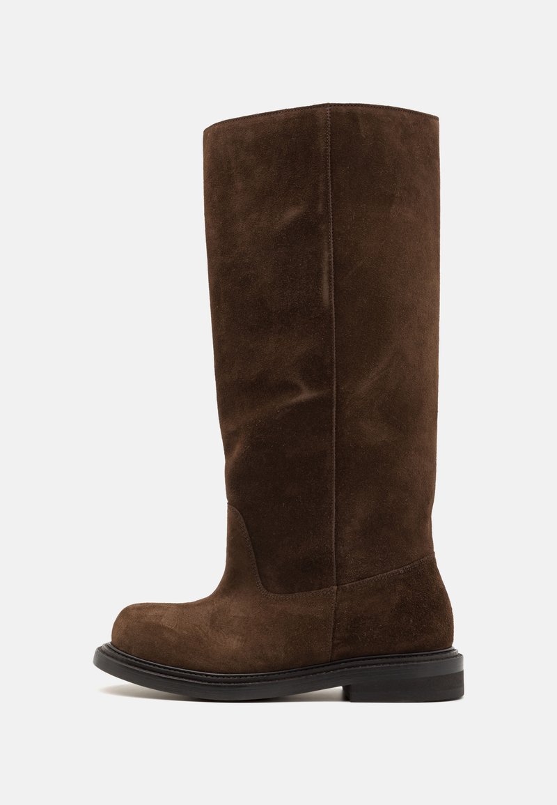 Stivale al ginocchio in suede marrone con punta rotonda, suola nera piatta e cuciture minime, caratterizzato da una texture liscia e linee di design pulite.