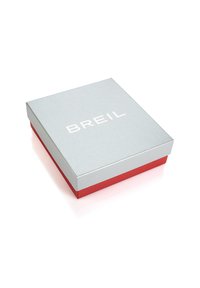 Caja rectangular plateada con una base roja y la palabra "BREIL" estampada en blanco en la superficie superior. Textura suave, diseño minimalista.
