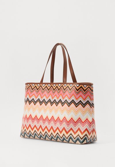 Geantă tip tote cu un model în dungi (chevron) în nuanțe de corai, roz și maro. Are un material durabil, cu mânere din piele maro și o formă structurată.