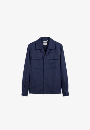 Marineblå, langærmet skjorte med knapper, to brystlommer med klap og spids krave, vist mod en hvid baggrund.