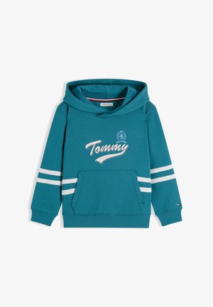 Turkusowa bluza z kapturem z przednią kieszenią, białe paski na rękawach, logo "Tommy" w formie napisu i herb na piersi, prążkowane mankiety oraz mała flaga na lewym nadgarstku.
