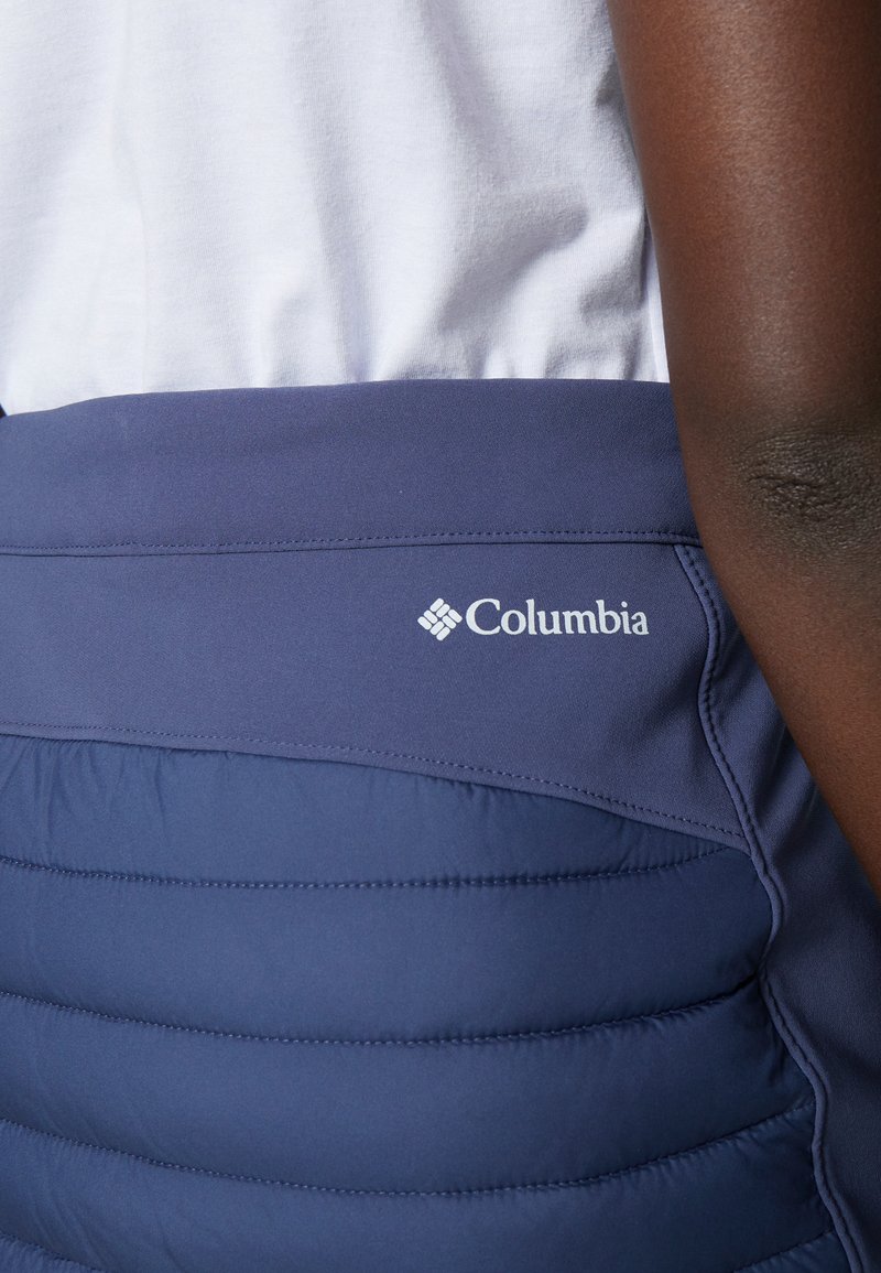 Granatowa spódnica Columbia o pikowanej fakturze i gładkim pasie. Posiada białe logo po lewej stronie oraz subtelne detale stębnowania.