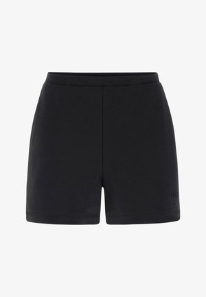 Pantaloncini neri aderenti con una fascia elastica in vita e il logo "Guess" discretamente inciso vicino all'orlo inferiore sulla gamba sinistra.