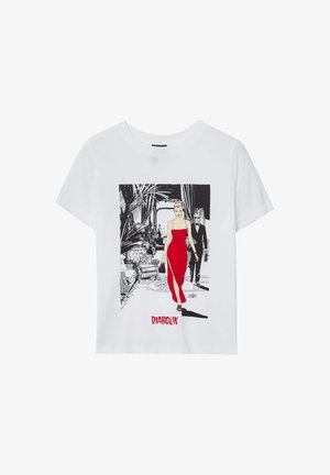 T-shirt bianco in cotone con una grafica di una donna in un vestito rosso, con il testo "DIABOLIK" sottostante, su uno sfondo interiore stilizzato.