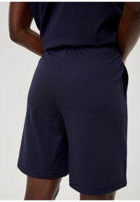 Marineblaue Shorts aus glattem Stoff mit einem elastischen Bund, seitlichen Taschen und einer entspannten Passform.
