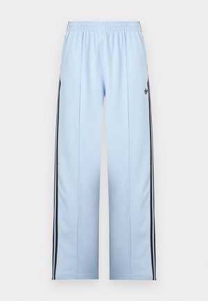 Pantaloni sportivi albastru deschis cu talie elastică, dungi negre pe lateral și un mic logo negru Adidas pe coapsa stângă.