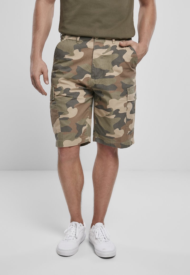 Pantaloni cargo mimetici in verde, marrone e beige, caratterizzati da molteplici tasche e una vestibilità rilassata. Realizzati in tessuto resistente, di lunghezza al ginocchio.