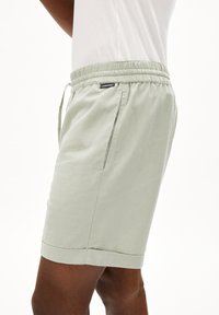 Lichtgroene shorts met een zachte textuur, elastische tailleband, koord, zijzakken en opgerolde manchetten.