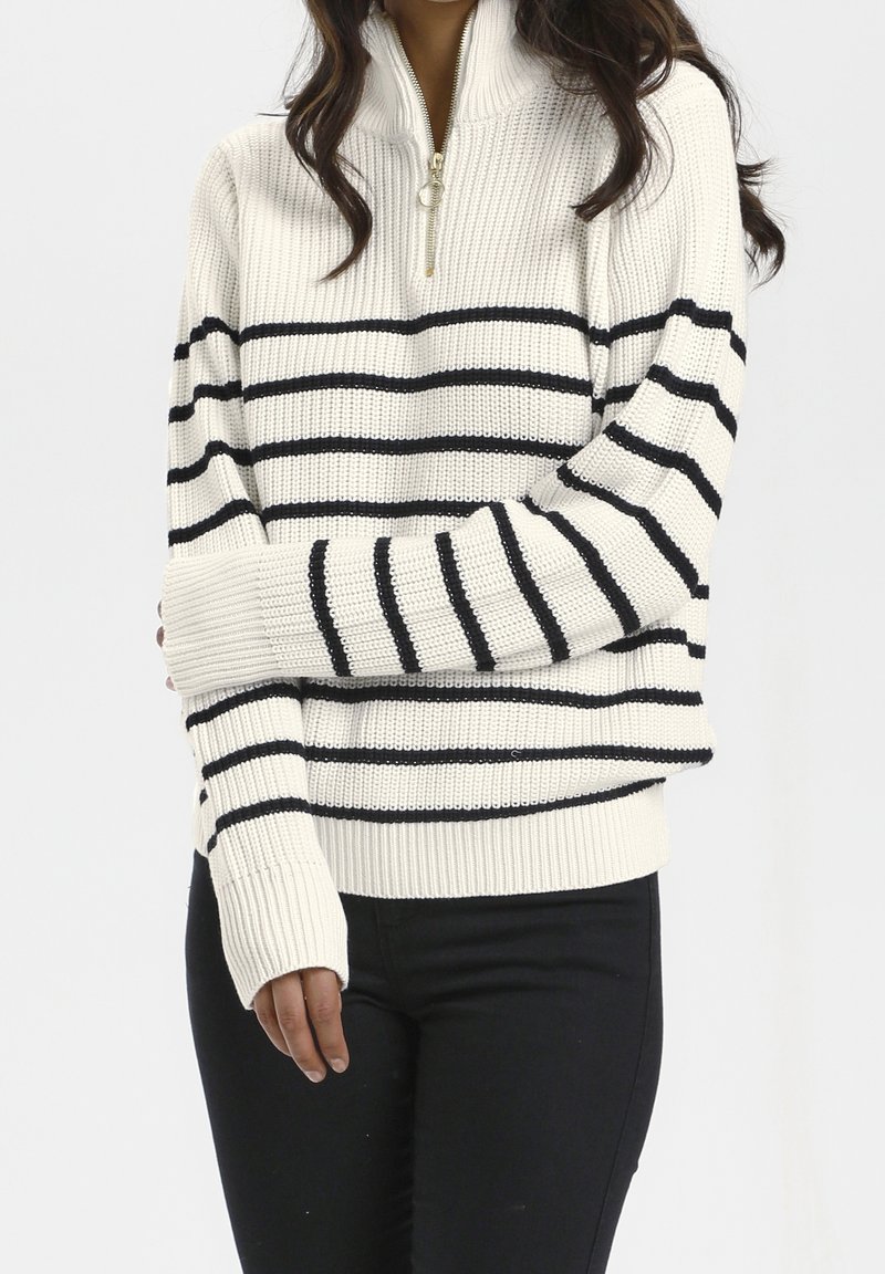Suéter de punto blanco con rayas horizontales negras, cuello con media cremallera, puños y dobladillo acanalados, que presenta un tejido texturizado.