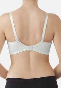 Weißer BH mit dünnen, glatten Trägern und einem strukturierten Bund. Der Rücken hat einen Haken- und Ösenverschluss und ein minimalistisches Design.