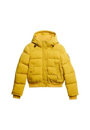 Chaqueta acolchada amarilla con diseño corto, capucha y dos bolsillos frontales. Presenta cierres a presión y puños de canalé para mayor calidez y ajuste.