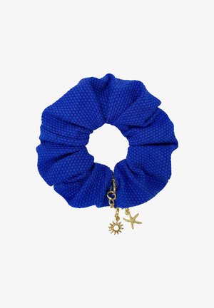 Niebieska gumka do włosów z fakturą materiału, ozdobiona złotymi zawieszkami w kształcie słońca i rozgwiazdy, przymocowana do małej złotej zapinki.