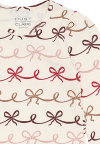 Langärmliges Rippoberteil in Creme mit einem sich wiederholenden Muster aus Schleifen in Rot-, Pink-, Braun- und Dunkelbraun-Tönen. Weiche Textur und runder Ausschnitt.