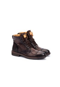 Botas de cuero marrón con punta redonda, paneles texturizados y forro en tono marrón claro. Cuentan con cordones y una suela resistente.