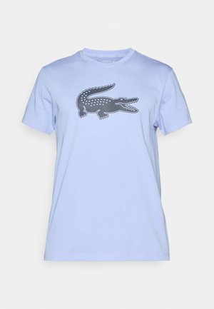 Lyseblå bomulds t-shirt med et mørkeblåt krokodillemotiv på fronten. Korte ærmer og klassisk rund halsdesign.