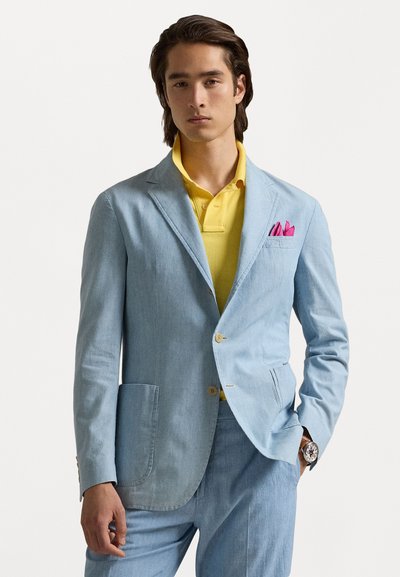  Lichtblauwe linnen blazer met notched lapels en een borstzak, gecombineerd met een gele polo. Bevat een roze pochette en horloge.