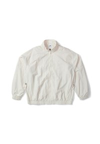 Veste coupe-vent légère de couleur crème, avec col montant, poignets élastiques et poches latérales zippées. Comprend un petit logo près de la poitrine.
