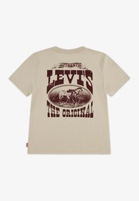 Béžové tričko s krátkým rukávem s bordó grafickým potiskem, na kterém je napsané "Levi’s The Original" a ilustrace koně uvnitř oválu.