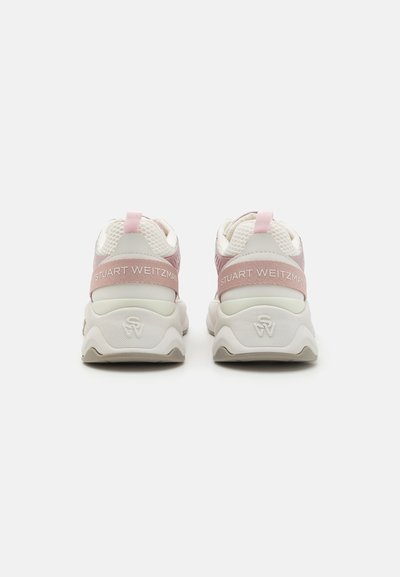 Valkoinen ja vaaleanpunainen urheilujalkine, jossa on verkkomateriaalia yläosassa, pehmustettu pohja ja merkkihiusnauha, jossa on teksti "STUART WEITZMAN".