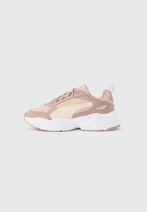 Basket Puma beige et rose blush avec logo latéral texturé, semelle blanche épaisse, lacets sur le devant et languette au talon.