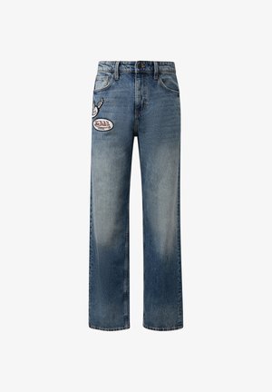 Vaqueros de mezclilla azul de pierna recta con parches frontales, incluyendo un zapato alado y el logo "Von Dutch Original" en el muslo izquierdo.