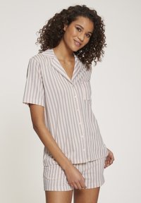 Pajama set kratkih rukava s prugastim uzorkom u pastelnim bojama, koji se sastoji od košulje s dugmadima, detaljem džepa i odgovarajućim kratkim hlačama. Mekani materijal s opuštenim krojem.