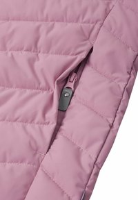 Giacca puffer rosa chiaro con tasca con zip, caratterizzata da dettagli trapuntati e una texture liscia. Il tirante della zip è di colore contrastante.