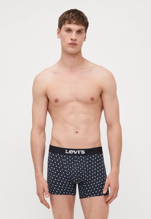 Shorts de boxe noirs avec un motif en losanges blanc, dotés d'une ceinture de marque noire. Tissu lisse avec une coupe ajustée.