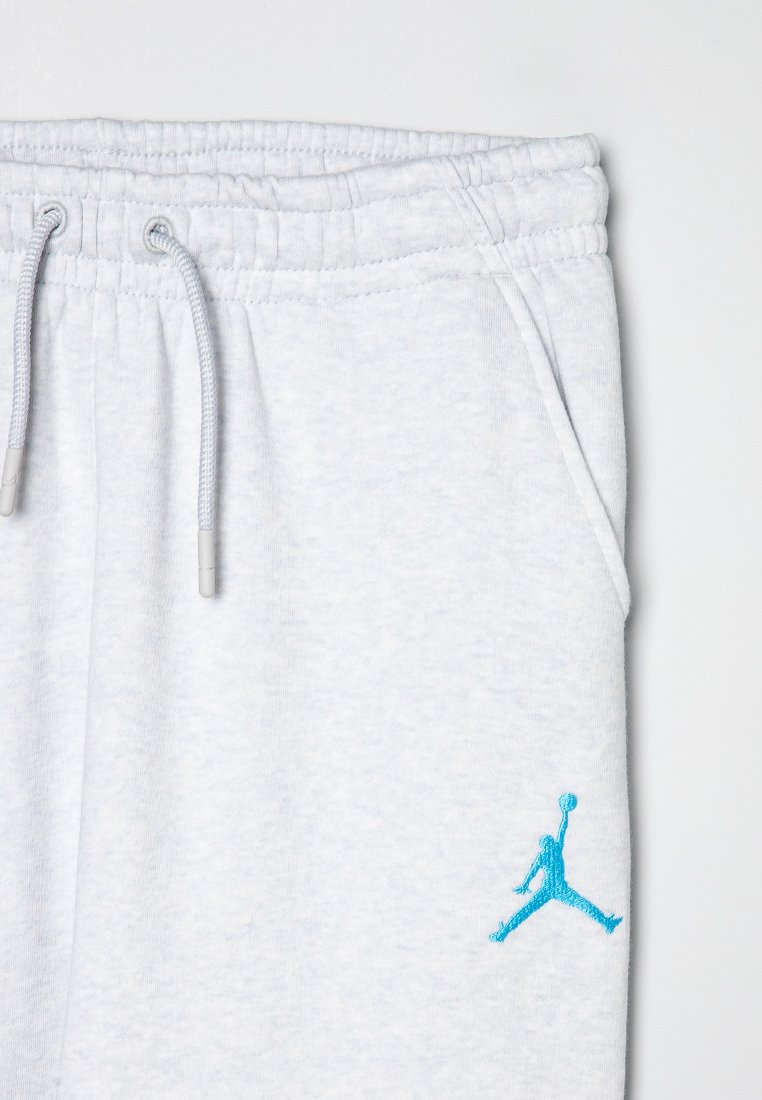 Hellgraue Jogginghosen aus weichem Stoff, mit einem elastischen Bund, Kordelzug und einem blauen gestickten Jumpman-Logo auf der Vorderseite.