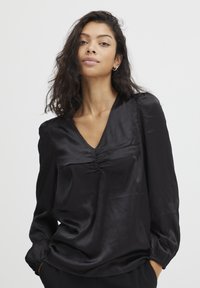 Schwarze Satin-Bluse mit V-Ausschnitt, gerafftem Detail an der Brust und langen, gepufften Ärmeln mit elastischen Bündchen. Glatte Textur und lässige Passform.